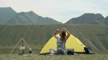Girl tourist relaxes raising arms up after sleeping in the morning in sunny weather. video