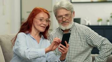 uma Senior casal dentro seus anos 60 faço a conectados compra de escolhendo uma produtos usando uma Smartphone. video