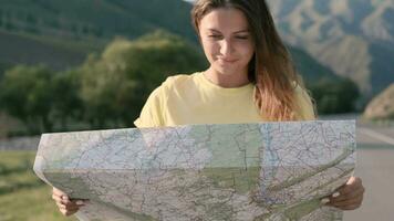 portrait. magnifique femelle touristique avec une carte dans mains voyages en marchant sur le Autoroute dans une bien ambiance video