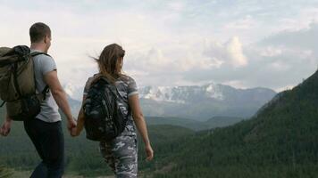 Happy couple rejoices in success and cuddling while standing on the top of the mountain video