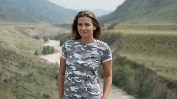 portret van een mooi meisje toerist Aan een achtergrond van bergen en een rivier- video
