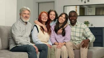 Portrait of multi ethnic family of different age generations at home on the sofa. video