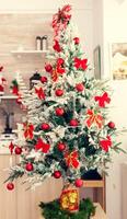 Beautiful decorated christmas tree in empty kitchen. Kitchen on christmas day with nobody in the room decorated with x-mas tree and garlands photo