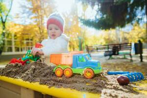 the child plays cars on the playground photo