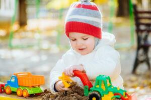 the child plays cars on the playground photo