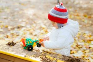 niño jugando excavador en el calle foto