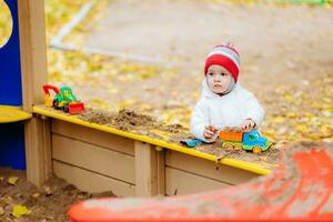 the child plays cars on the playground photo