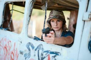 A girl with a pistol in her hand undergoes military training and learns to shoot. photo