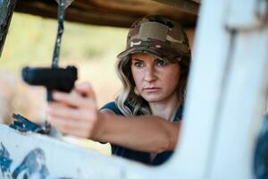 A girl with a pistol in her hand undergoes military training and learns to shoot. photo