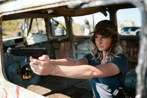 A girl with a pistol in her hand learns to shoot at the shooting range photo