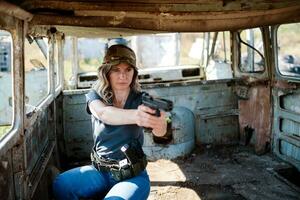 A girl with a pistol in her hand learns to shoot at the shooting range photo