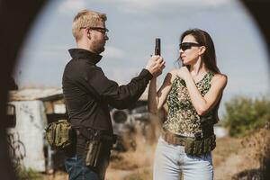 A girl learns to shoot a pistol at a shooting range with an instructor photo