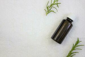 Rosemary oil on a white towel, close up. Natural cosmetics for body and hair care. Flat lay. photo