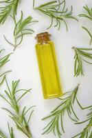 Rosemary oil and fresh rosemary on a white towel. photo