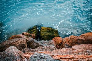 Close up water with stones on the beach concept photo. Underwater rock. Mediterranean winter sea. photo