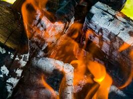 Close-up of a fire with firewood, coals and ashes. photo