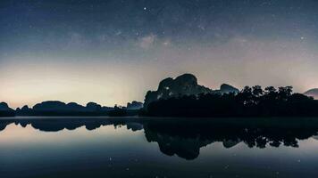 melkachtig manier en ster tegen nacht lucht reflecteren Aan water video