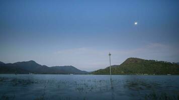 ein Mond ist auf Himmel mit wolkig Betrachtung auf Wasser video