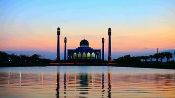 silhouette mosquée à le coucher du soleil réfléchir sur l'eau video