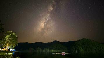 melkachtig manier en ster tegen nacht lucht reflecteren Aan water video