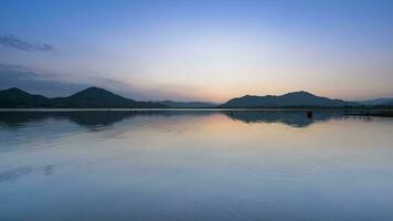 puesta de sol reflexión en agua en represa video