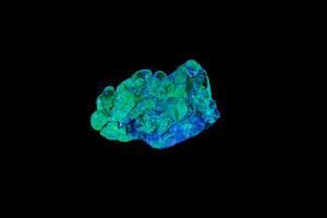 macro mineral stone opal under ultraviolet light on a black background photo