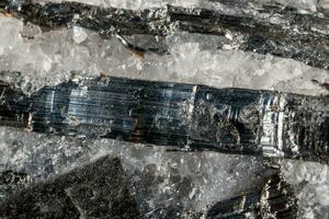 Macro mineral stone Stibnite quartz on a black background photo