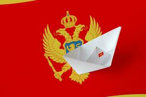 Montenegro flag depicted on paper origami ship closeup. Handmade arts concept photo