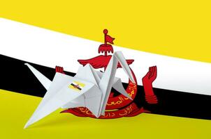 Brunei Darussalam flag depicted on paper origami crane wing. Handmade arts concept photo