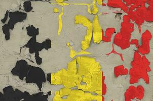 Belgium flag depicted in paint colors on old obsolete messy concrete wall closeup. Textured banner on rough background photo