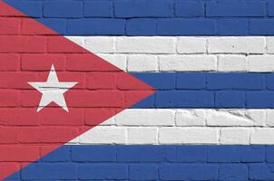 Cuba flag depicted in paint colors on old brick wall. Textured banner on big brick wall masonry background photo
