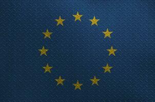 European union flag depicted in paint colors on old brushed metal plate or wall closeup. Textured banner on rough background photo