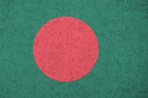 Bangladesh flag depicted in bright paint colors on old relief plastering wall. Textured banner on rough background photo