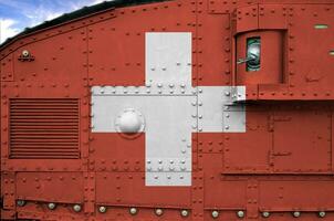 Switzerland flag depicted on side part of military armored tank closeup. Army forces conceptual background photo