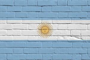 Argentina flag depicted in paint colors on old brick wall. Textured banner on big brick wall masonry background photo