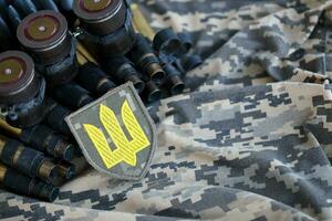 Ukrainian army symbol on machine gun belt lies on ukrainian pixeled military camouflage photo