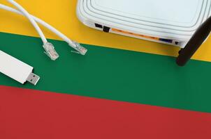 Lithuania flag depicted on table with internet rj45 cable, wireless usb wifi adapter and router. Internet connection concept photo