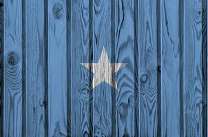 Somalia bandera representado en brillante pintar colores en antiguo de madera pared. texturizado bandera en áspero antecedentes foto