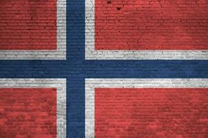 Norway flag depicted in paint colors on old brick wall. Textured banner on big brick wall masonry background photo