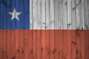 Chile flag depicted in bright paint colors on old wooden wall. Textured banner on rough background photo