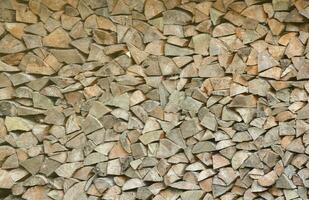 Firewood stacked near the wooden wall of old hut. Many chopped logs of firewood photo