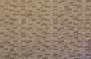 Dark brick wall pattern with chaotic masonry order. Background texture or resource for 3d texturing. Many bricks in big modern stone wall photo