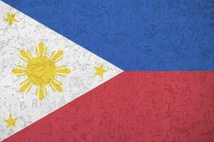 Philippines flag depicted in bright paint colors on old relief plastering wall. Textured banner on rough background photo