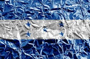 Honduras flag depicted in paint colors on shiny crumpled aluminium foil closeup. Textured banner on rough background photo