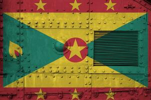 Grenada flag depicted on side part of military armored tank closeup. Army forces conceptual background photo