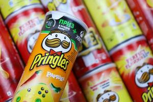 KHARKOV, UKRAINE - MARCH 30, 2021 Many Pringles cylinder chips boxes with varios colors and flavours. American brand of stackable potato-based crisps photo