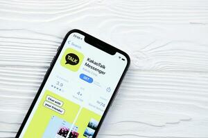 KHARKOV, UKRAINE - MARCH 5, 2021 KakaoTalk Messenger icon and application from display screen on white table photo
