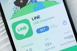 KHARKOV, UKRAINE - MARCH 5, 2021 Line messenger icon and application on display screen on white table photo