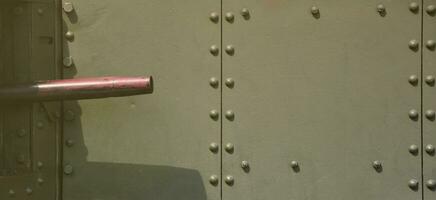 The texture of the wall of the tank, made of metal and reinforced with a multitude of bolts and rivets. Images of the covering of a combat vehicle from the Second World War with a guided machine gun photo