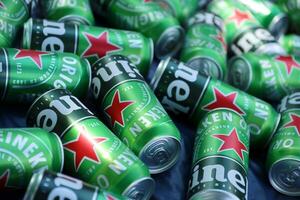 KHARKOV, UKRAINE - JULY 31, 2021 Green tin cans of Heineken lager beer produced by the Dutch brewing company Heineken N.V. photo